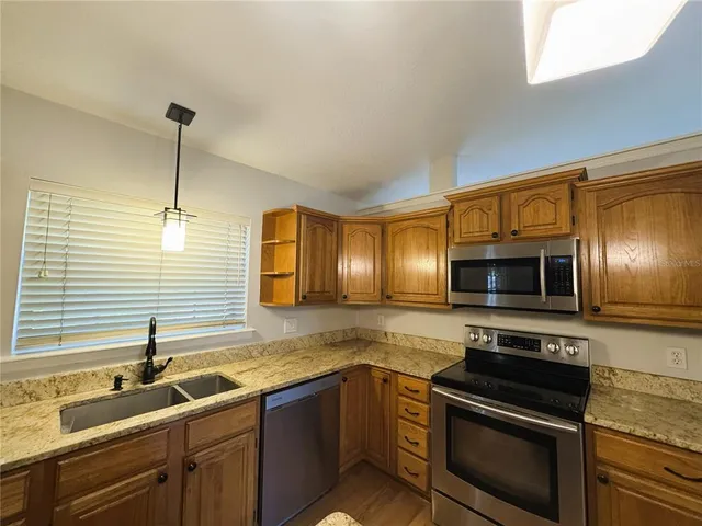 a kitchen with stainless steel appliances granite countertop a sink stove and microwave