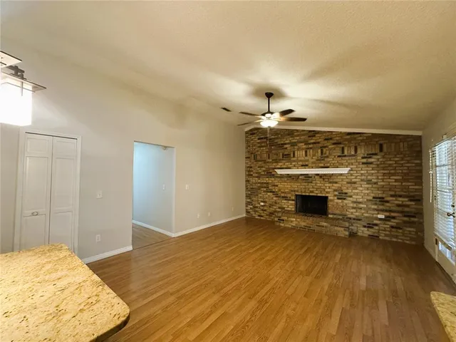 a view of a livingroom with wooden floor and a fireplace