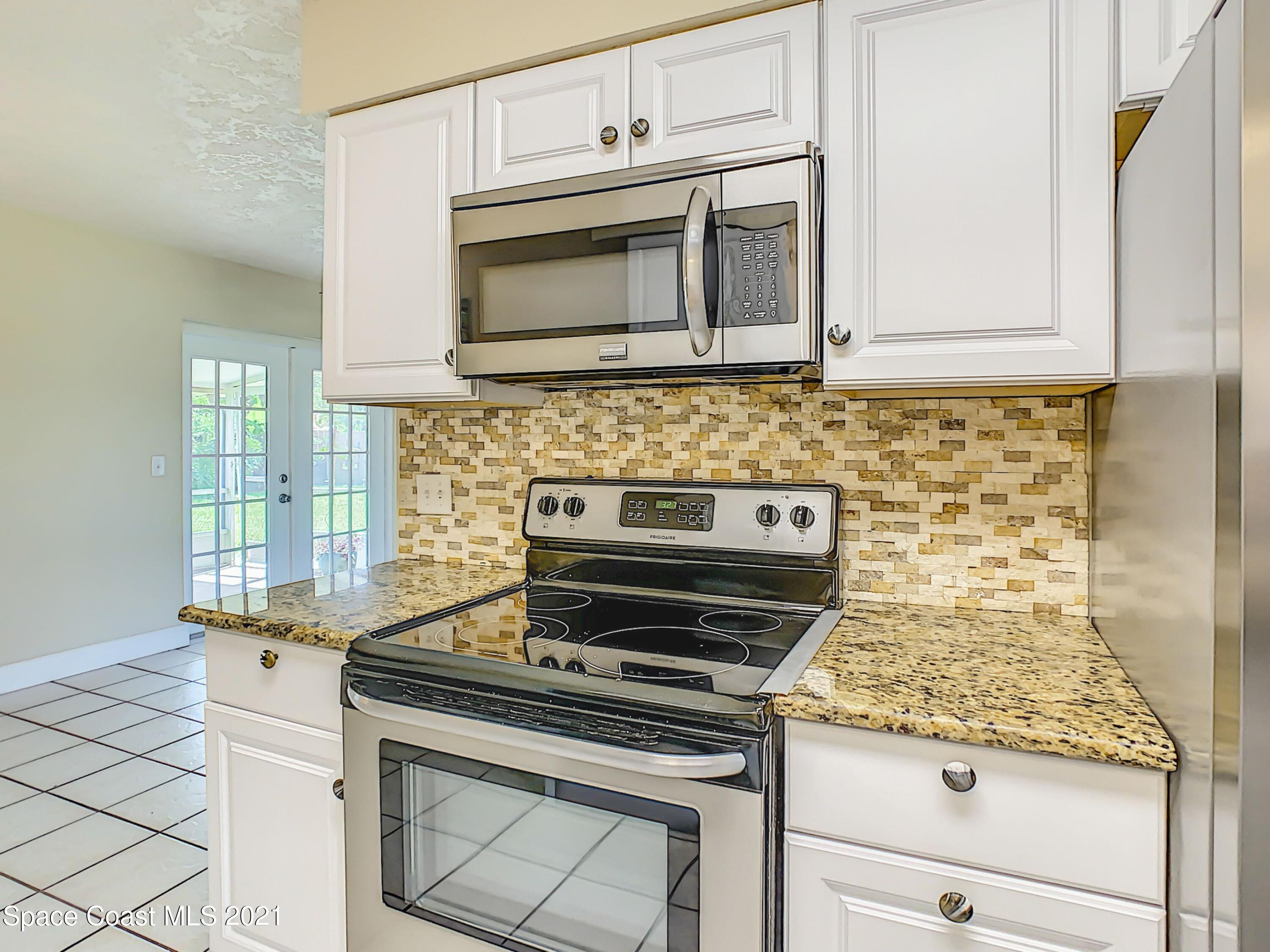 1091 Madrid Road Rockledge, FL 32955 - Photo 13 of 33 a stove top oven sitting inside of a kitchen