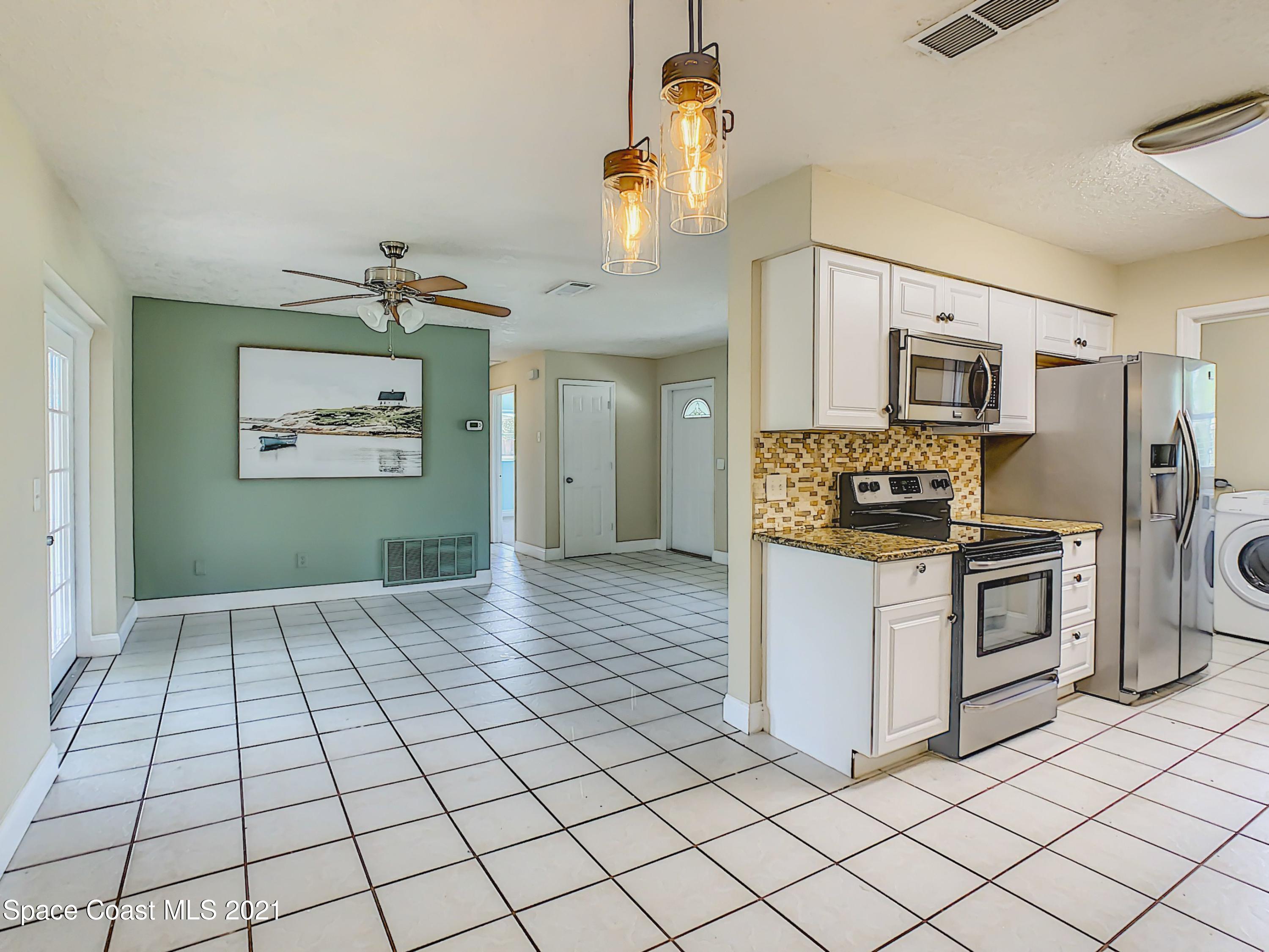 1091 Madrid Road Rockledge, FL 32955 - Photo 15 of 33 a kitchen with stainless steel appliances a refrigerator and a stove top oven