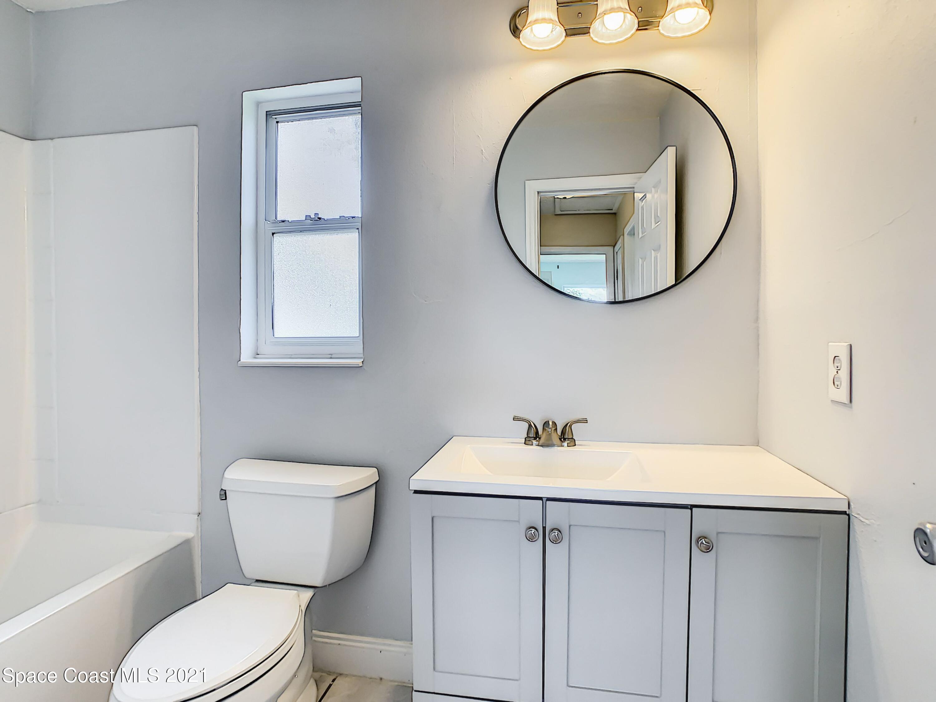 1091 Madrid Road Rockledge, FL 32955 - Photo 19 of 33 a white toilet sitting next to a bathroom sink