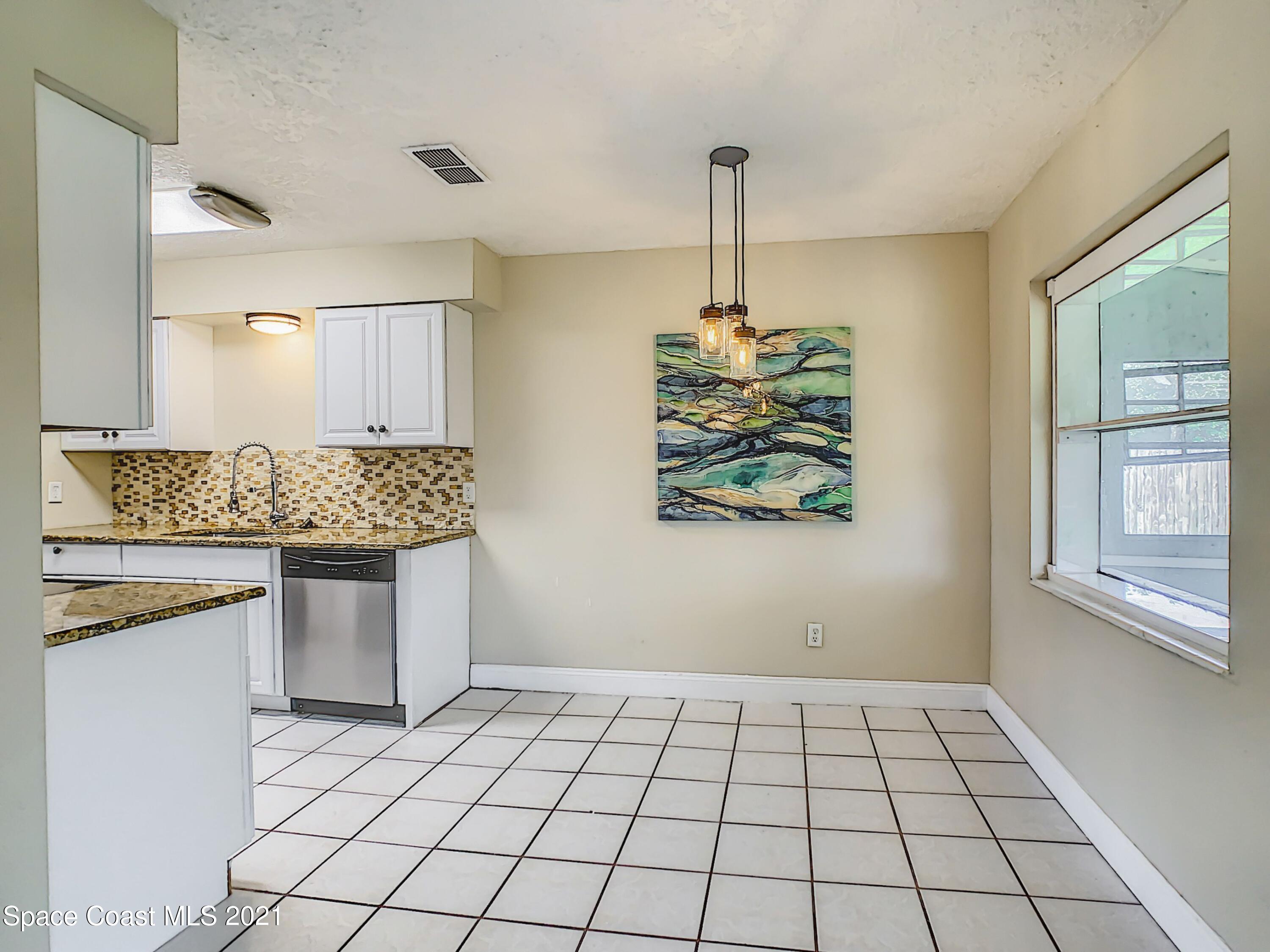 1091 Madrid Road Rockledge, FL 32955 - Photo 8 of 33 a view of a kitchen with kitchen island white cabinets and window