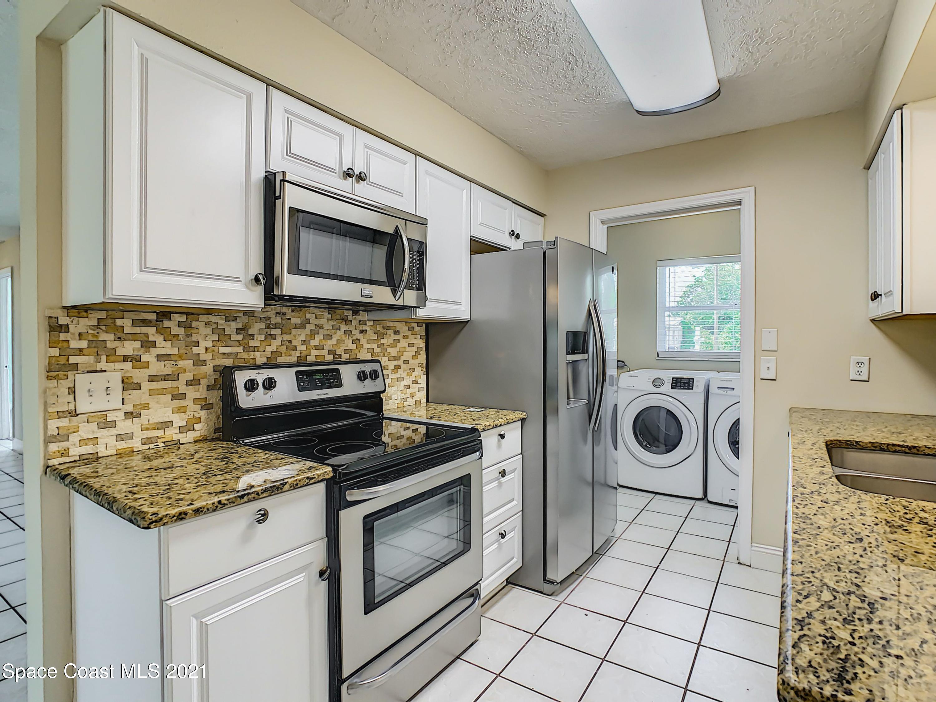 1091 Madrid Road Rockledge, FL 32955 - Photo 9 of 33 a kitchen with a stove and a microwave