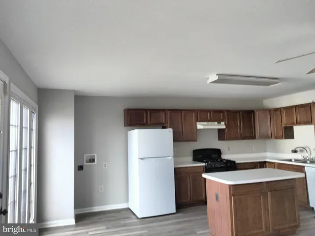 a kitchen with a refrigerator sink and wooden cabinets