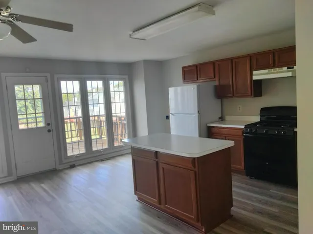 a kitchen with a refrigerator a stove top oven a sink and dishwasher with wooden floor