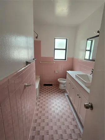 a bathroom with a sink a toilet and a mirror