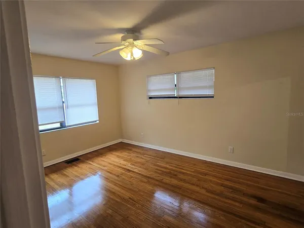 a view of empty room with wooden floor
