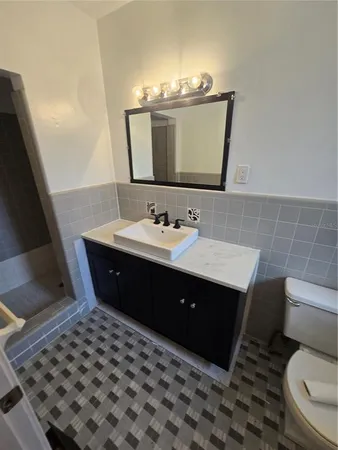 a bathroom with a sink vanity mirror and toilet