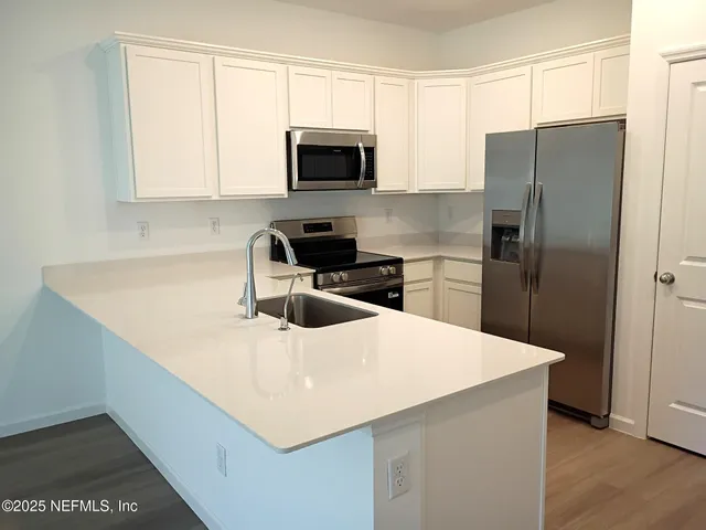 a kitchen with a appliances a sink and a microwave