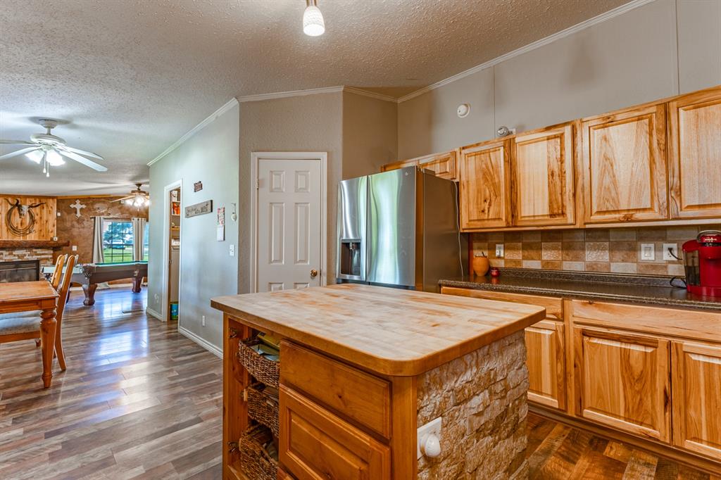 75 Southern Road Mineral Wells, TX 76067 - Photo 8 of 31 a open kitchen with stainless steel appliances granite countertop a stove top oven a sink dishwasher and wooden cabinets with wooden floor
