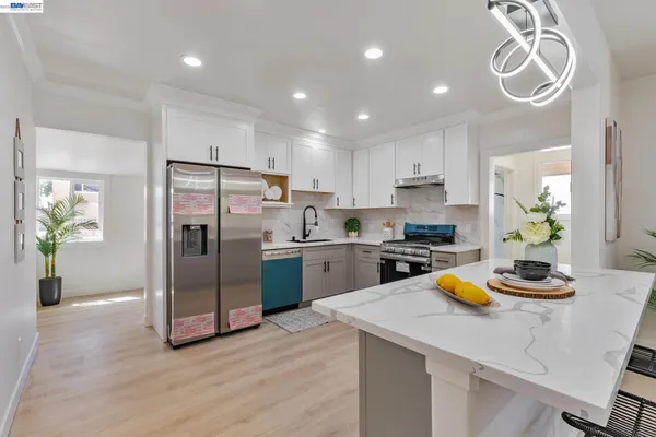 a kitchen with a refrigerator a stove and a wooden floor