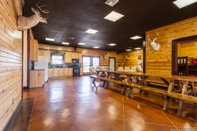 a view of a living room with kitchen view and appliances