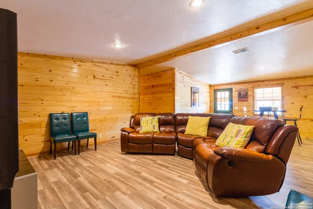 a living room with furniture wooden floor and a large window