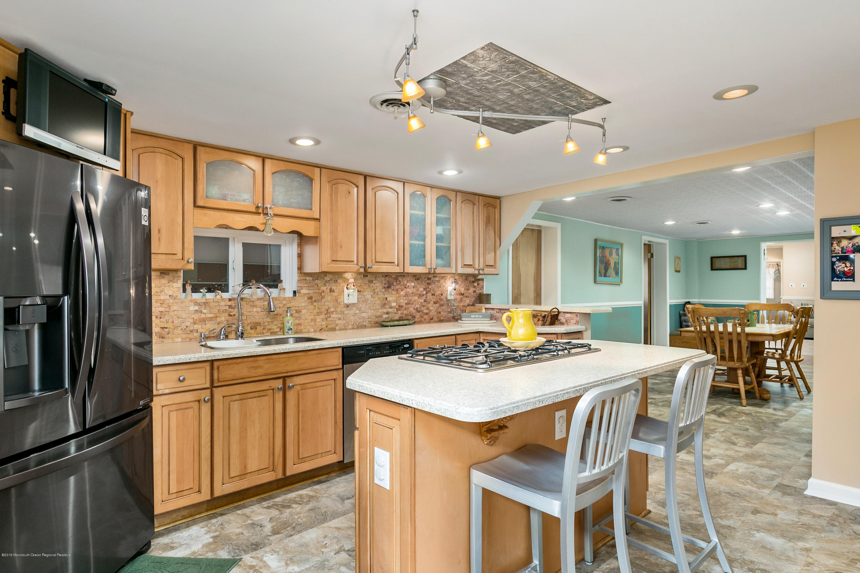 880 Monmouth Road Cream Ridge, NJ 08514 - Photo 12 of 45 a kitchen with stainless steel appliances granite countertop a stove top oven a refrigerator a sink and a dining table