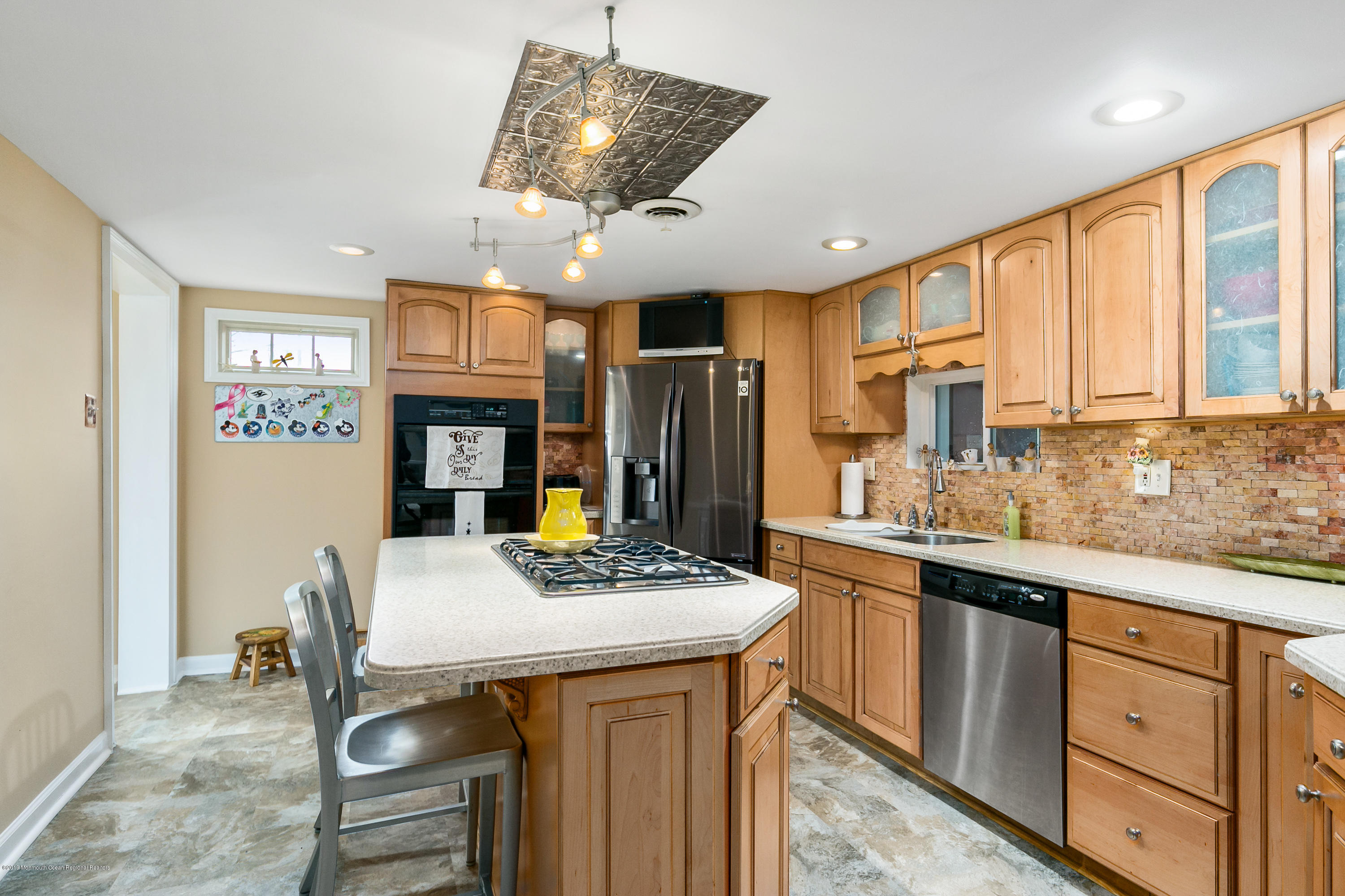 880 Monmouth Road Cream Ridge, NJ 08514 - Photo 10 of 45 a kitchen with stainless steel appliances granite countertop a stove refrigerator a sink dishwasher a dining table and chairs with wooden floor