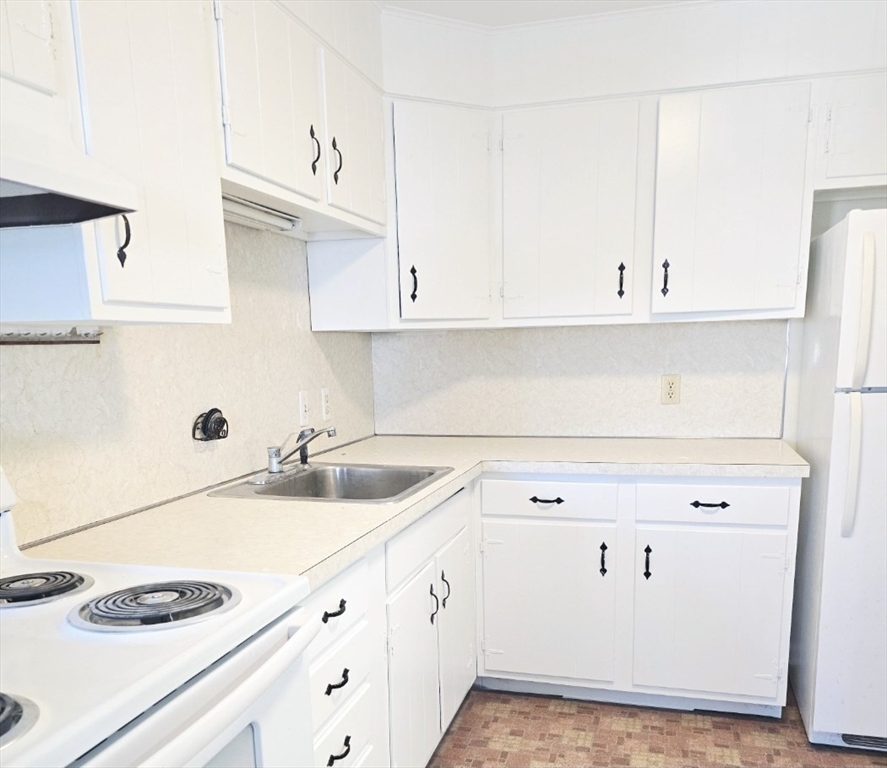567 Main Street, Unit 2 Shrewsbury, MA 01545 - Photo 5 of 7 a kitchen with cabinets and white appliances