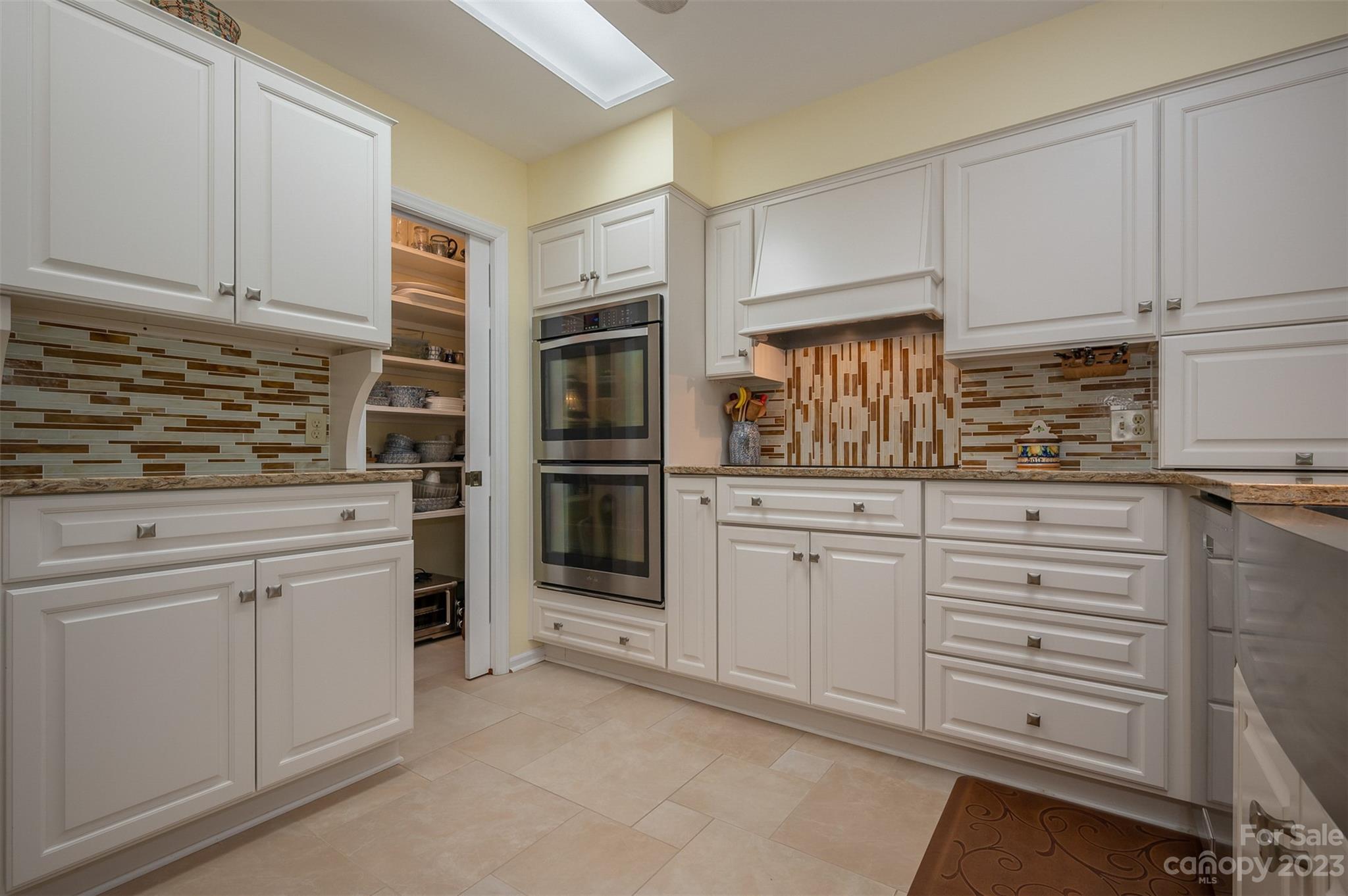 900 Club Road Tryon, NC 28782 - Photo 11 of 48 a kitchen with white cabinets and stainless steel appliances