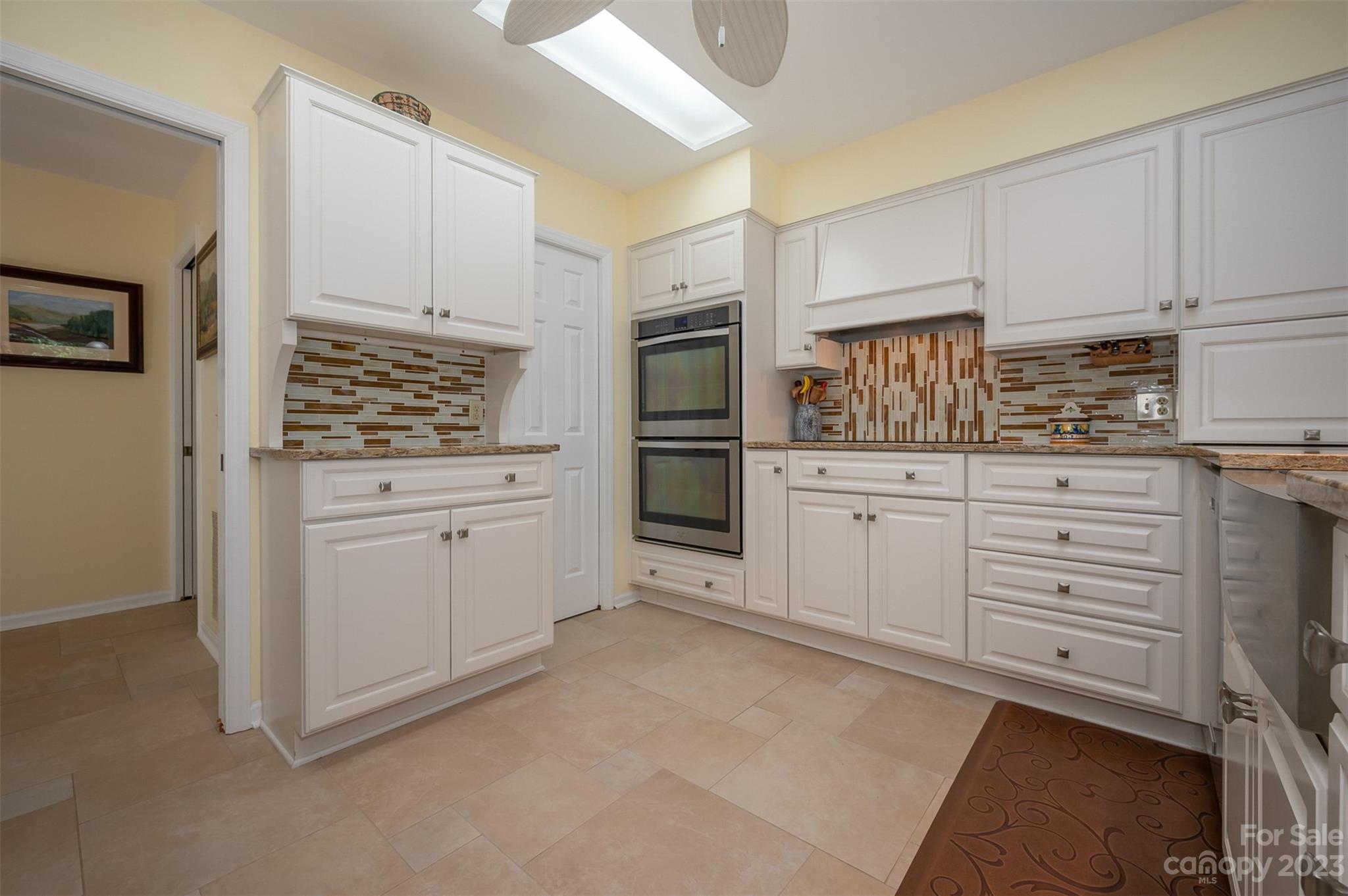 900 Club Road Tryon, NC 28782 - Photo 10 of 48 a kitchen with white cabinets and appliances