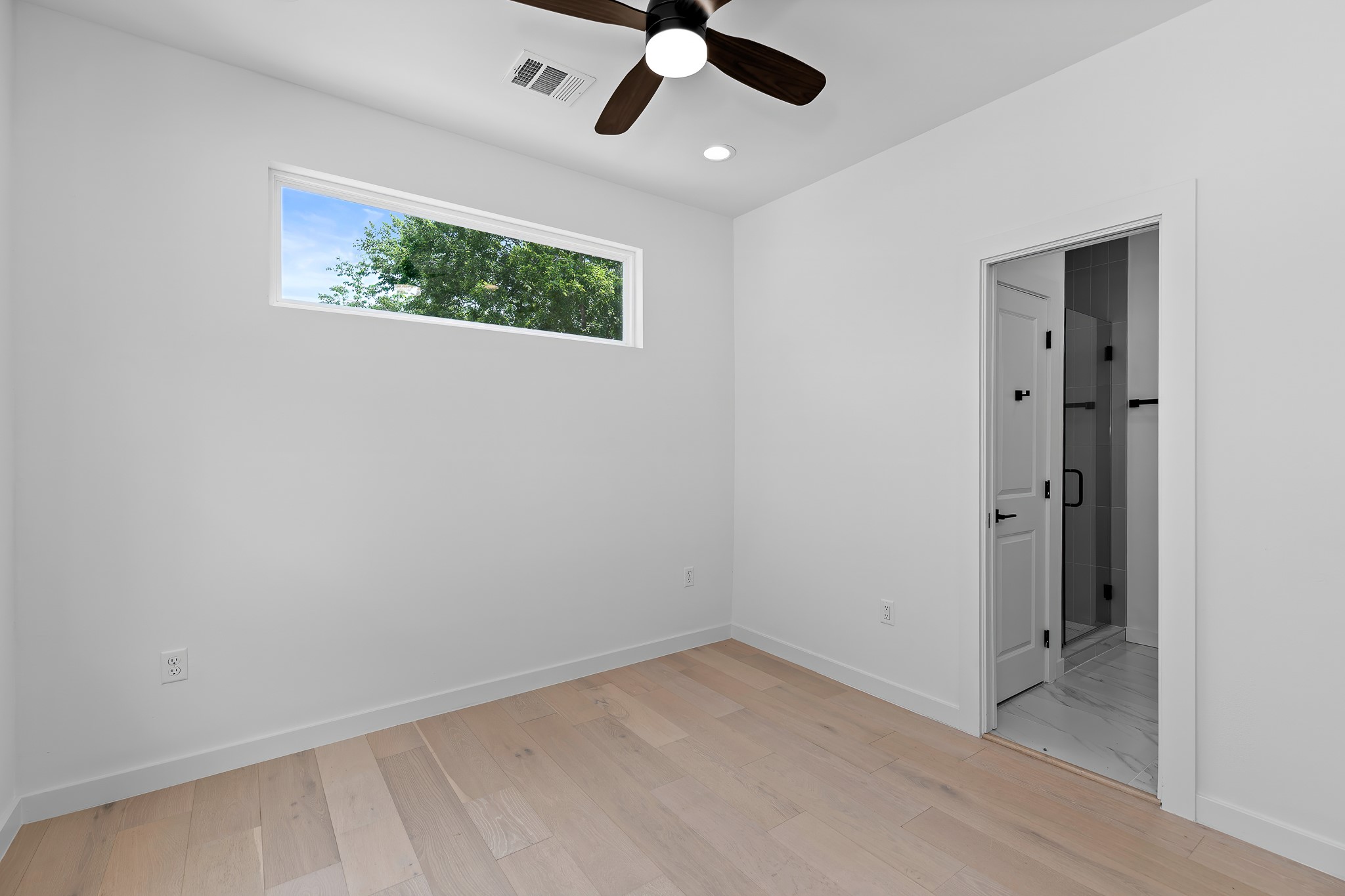 5305 Ledesma Road, Unit 4 Austin, TX 78721 - Photo 27 of 40 Blonde wood flooring extends through this naturally illuminated room, leading to a chic adjoining bathroom.