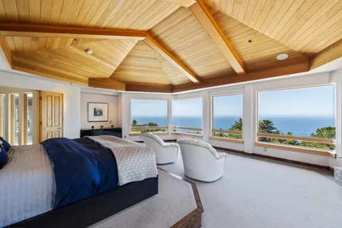 a bedroom with furniture and a large window