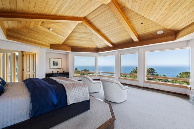 a bedroom with furniture and a large window