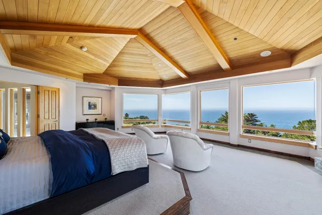 a bedroom with furniture and a large window