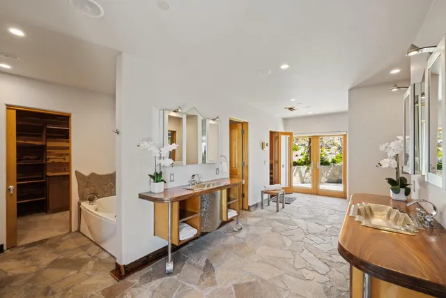 a large bathroom with a tub a double vanity sink and mirror