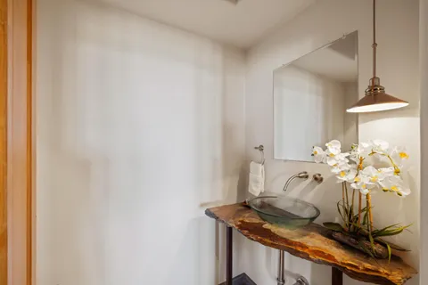 a bedroom with a bed couch and large window with outer view