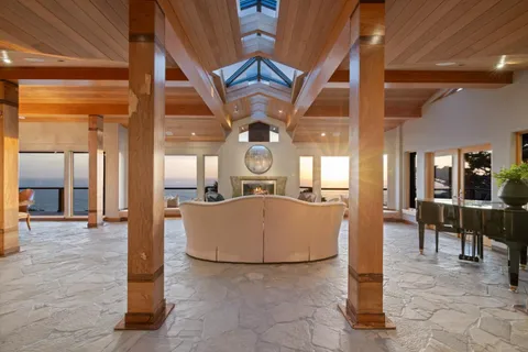 a living room with fireplace furniture and a large window