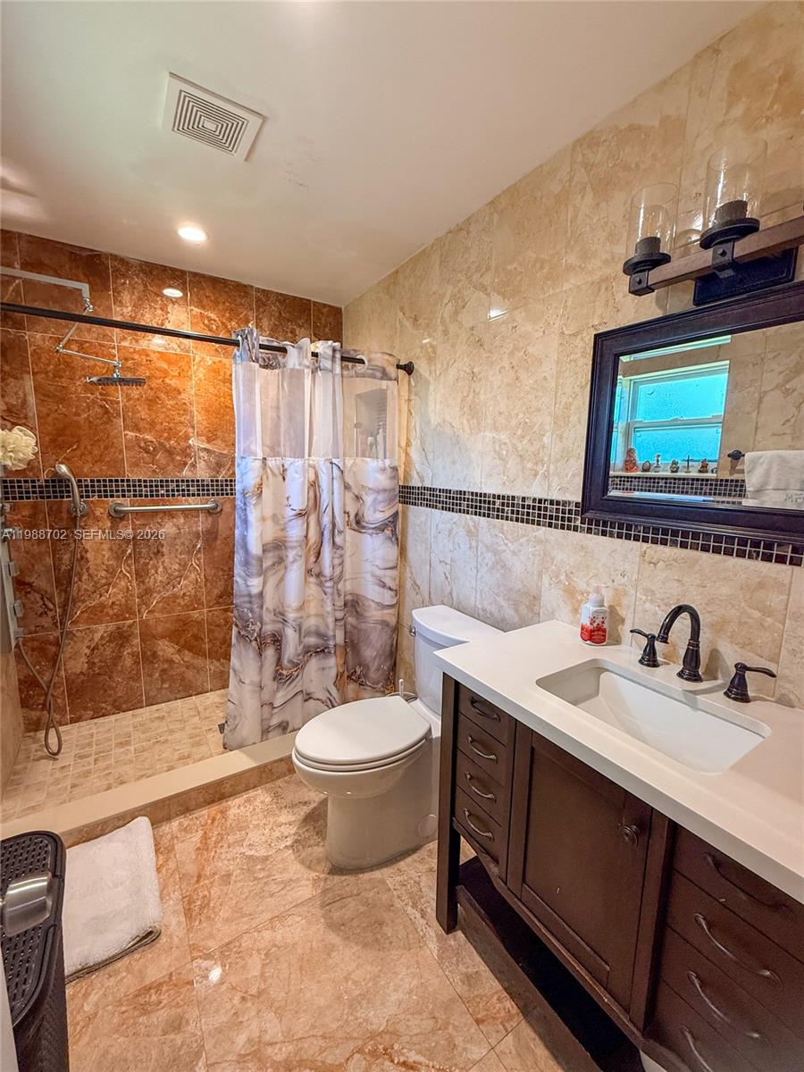 9971 Southwest 41st Terrace Miami, FL 33165 - Photo 12 of 21 a bathroom with a double vanity sink toilet and shower