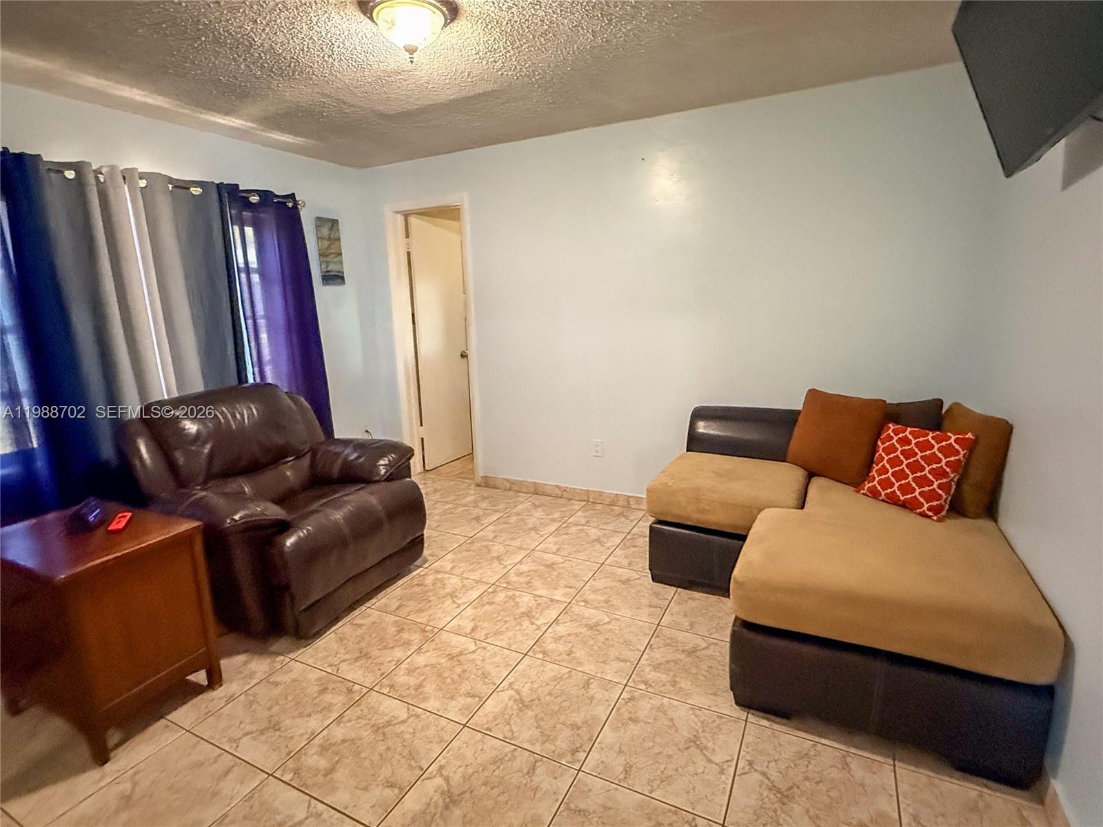 9971 Southwest 41st Terrace Miami, FL 33165 - Photo 13 of 21 a living room with furniture and a flat screen tv