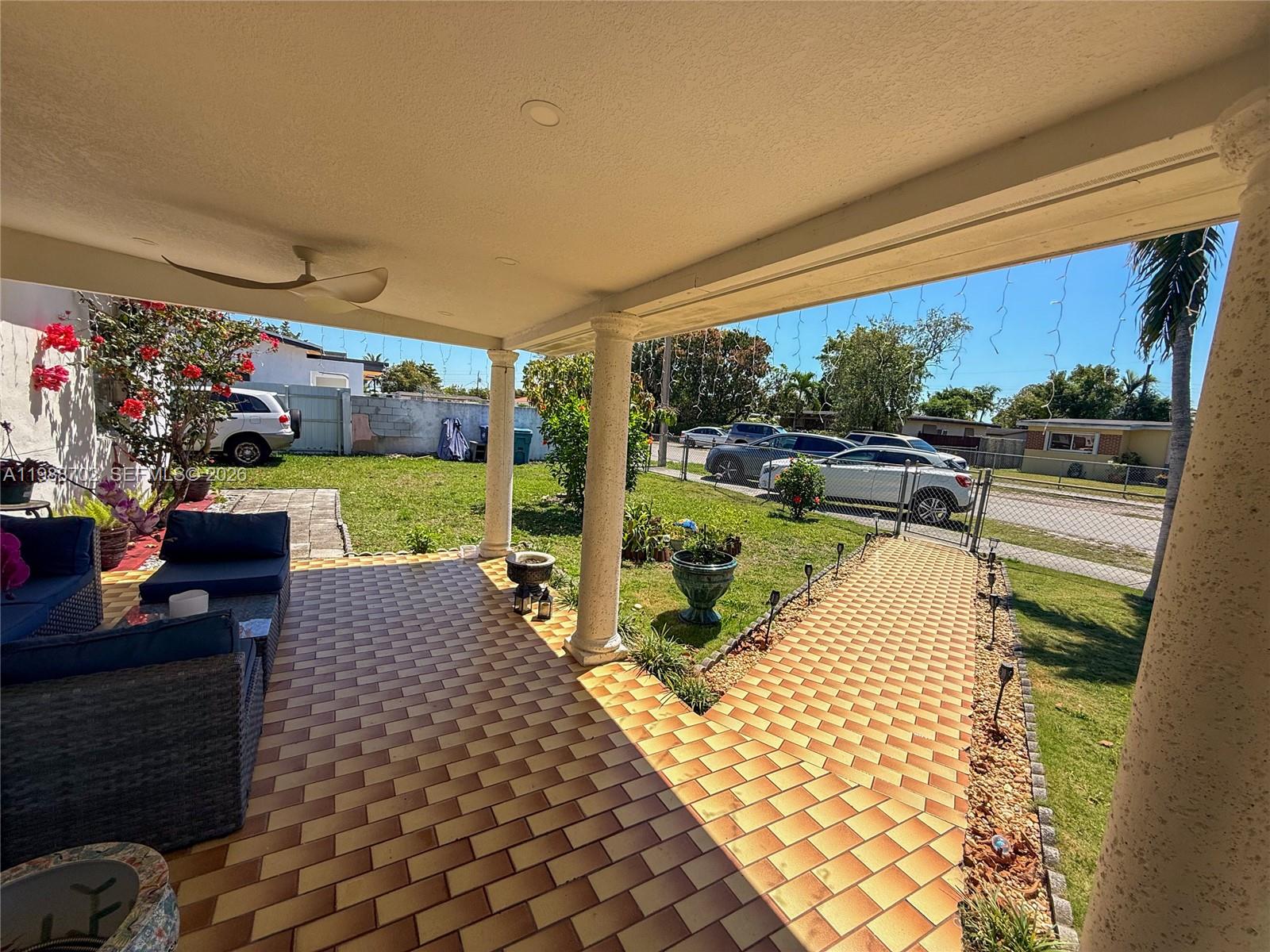 9971 Southwest 41st Terrace Miami, FL 33165 - Photo 2 of 21 a view of a patio with dining table and chairs with a garden