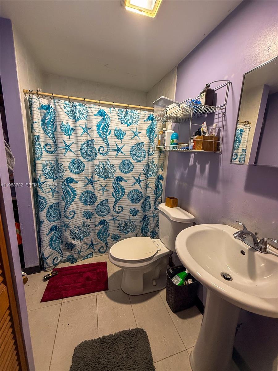 9971 Southwest 41st Terrace Miami, FL 33165 - Photo 4 of 21 a bathroom with a toilet and a sink a mirror