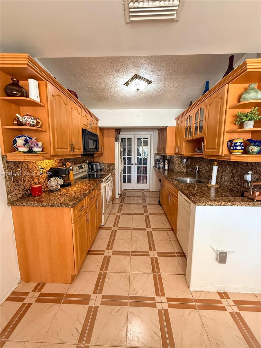 9971 Southwest 41st Terrace Miami, FL 33165 - Photo 9 of 21 a kitchen with stainless steel appliances granite countertop a stove a sink and a microwave