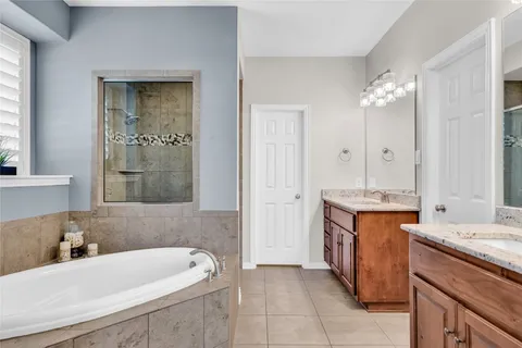 a bathroom with a tub sink and mirror