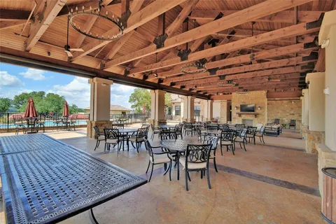 a view of swimming pool with outdoor seating and trees in the background