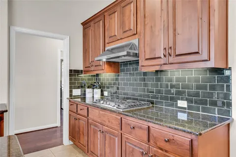 a kitchen with granite countertop a sink a stove and cabinets
