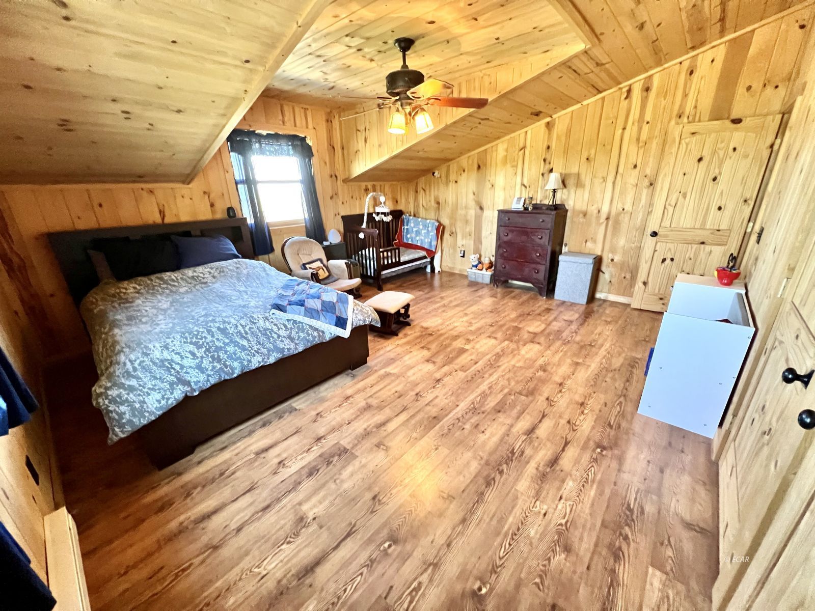 4513 Starr Valley Road Deeth, NV 89823 - Photo 26 of 49 a bedroom with a bed a mirror on dresser and a chandelier