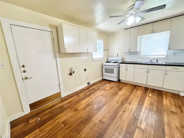 a kitchen with granite countertop white cabinets and white appliances