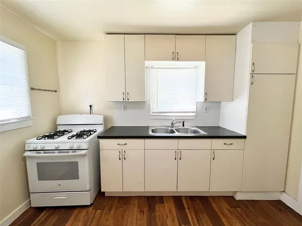 a kitchen with granite countertop white cabinets and white appliances