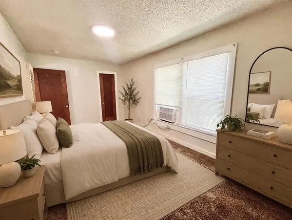 a bedroom with a bed and a dresser with mirror