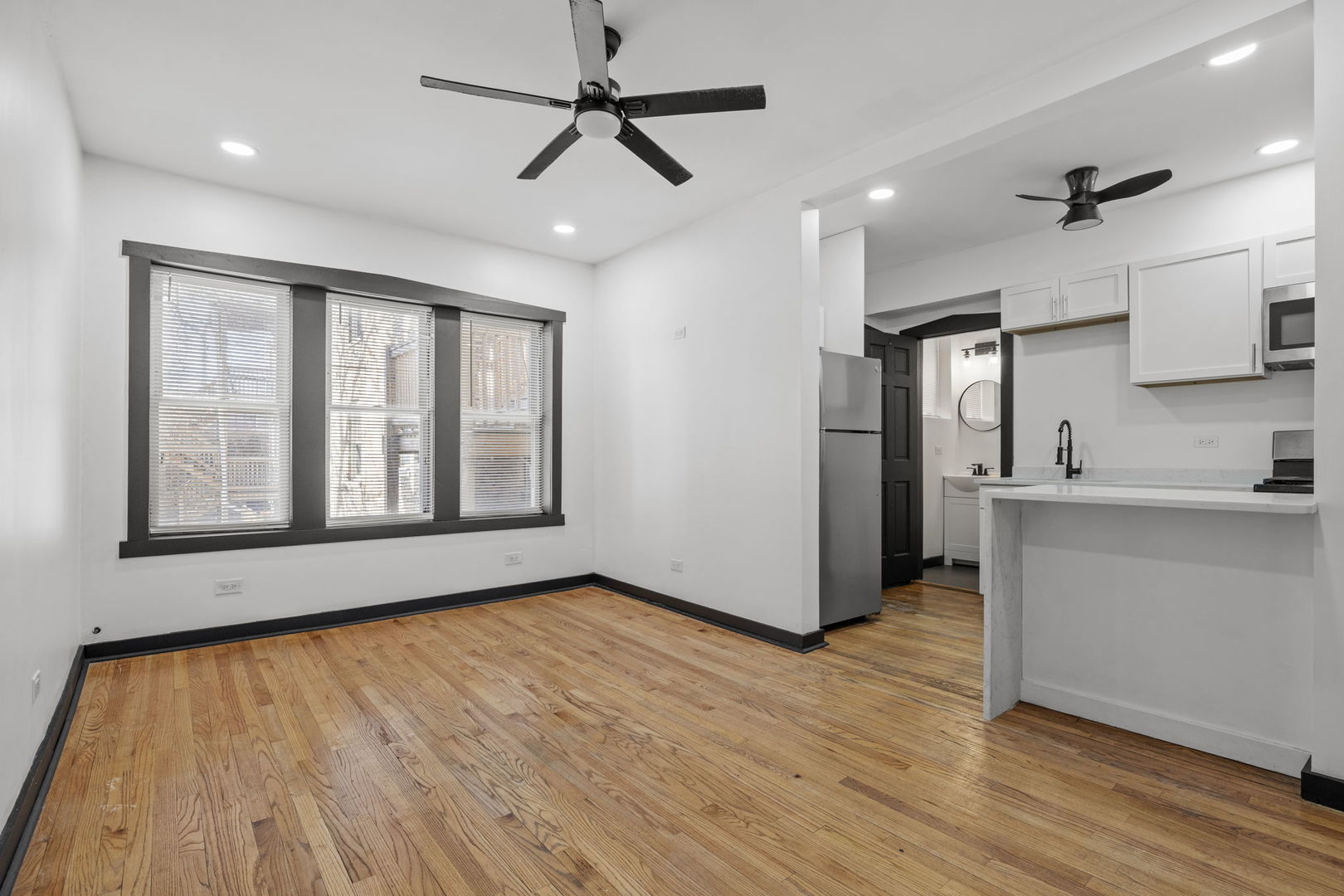 7202 South Indiana Avenue, Unit 1R Chicago, IL 60619 - Photo 2 of 9 a view of empty room with wooden floor and fan