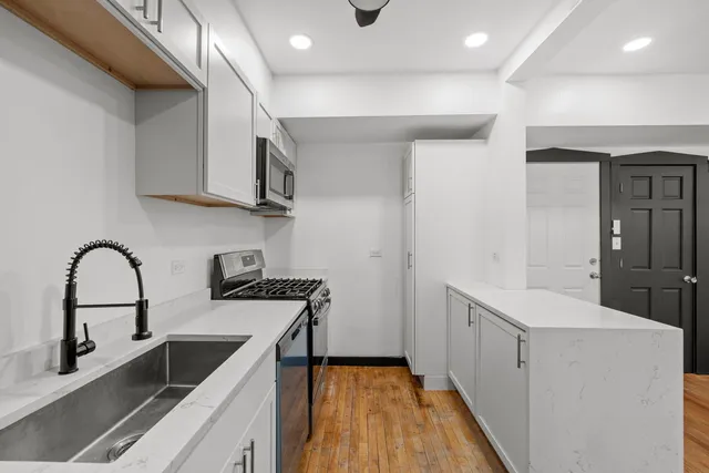 a kitchen with a sink a stove and cabinets