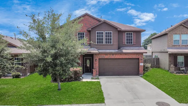 a front view of a house with a garden and yard