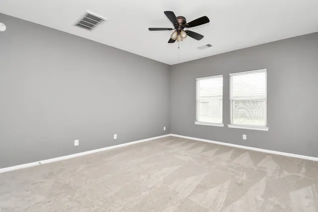 an empty room with a window and a fan