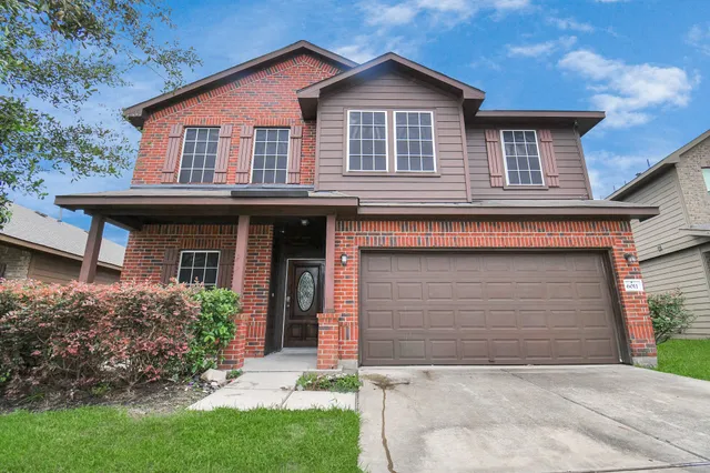 a front view of a house with a garden and garage