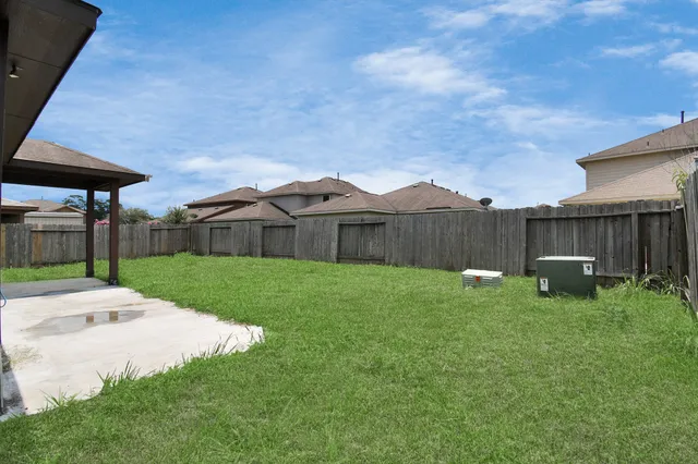 a view of a house with backyard and a fence