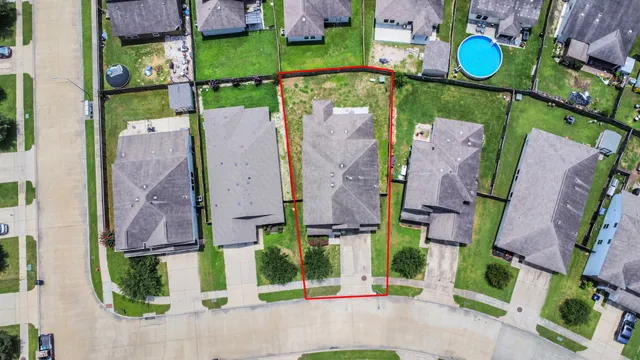 an aerial view of houses with outdoor space and parking