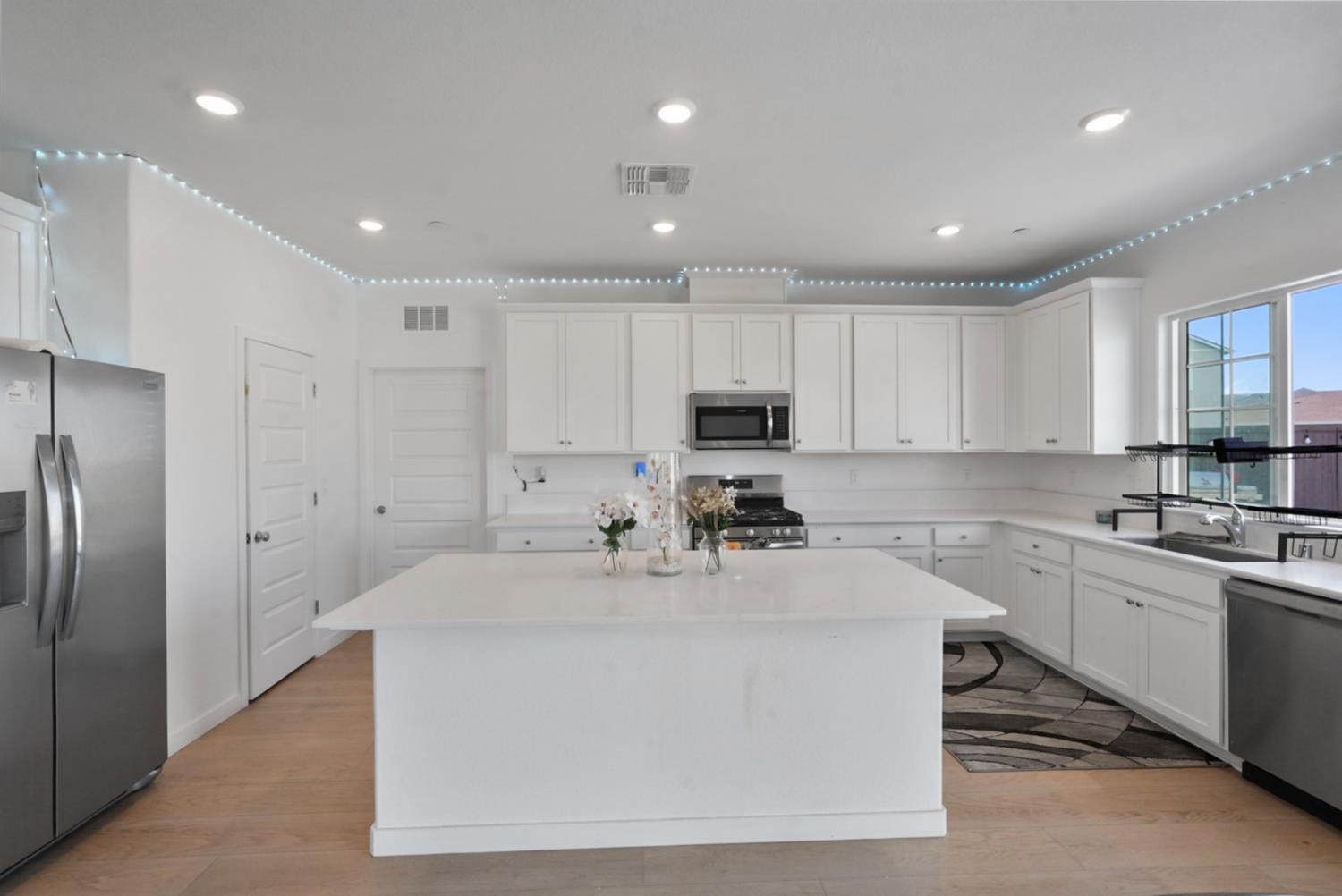 7041 Overlook Way Stockton, CA 95219 - Photo 20 of 31 a large white kitchen with kitchen island a sink stainless steel appliances and cabinets