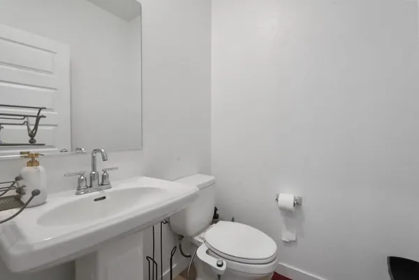 a bathroom with a sink mirror and toilet